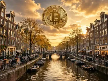 Amsterdam canal houses and bicycles at golden hour with a large golden Bitcoin coin in the sky above the canal